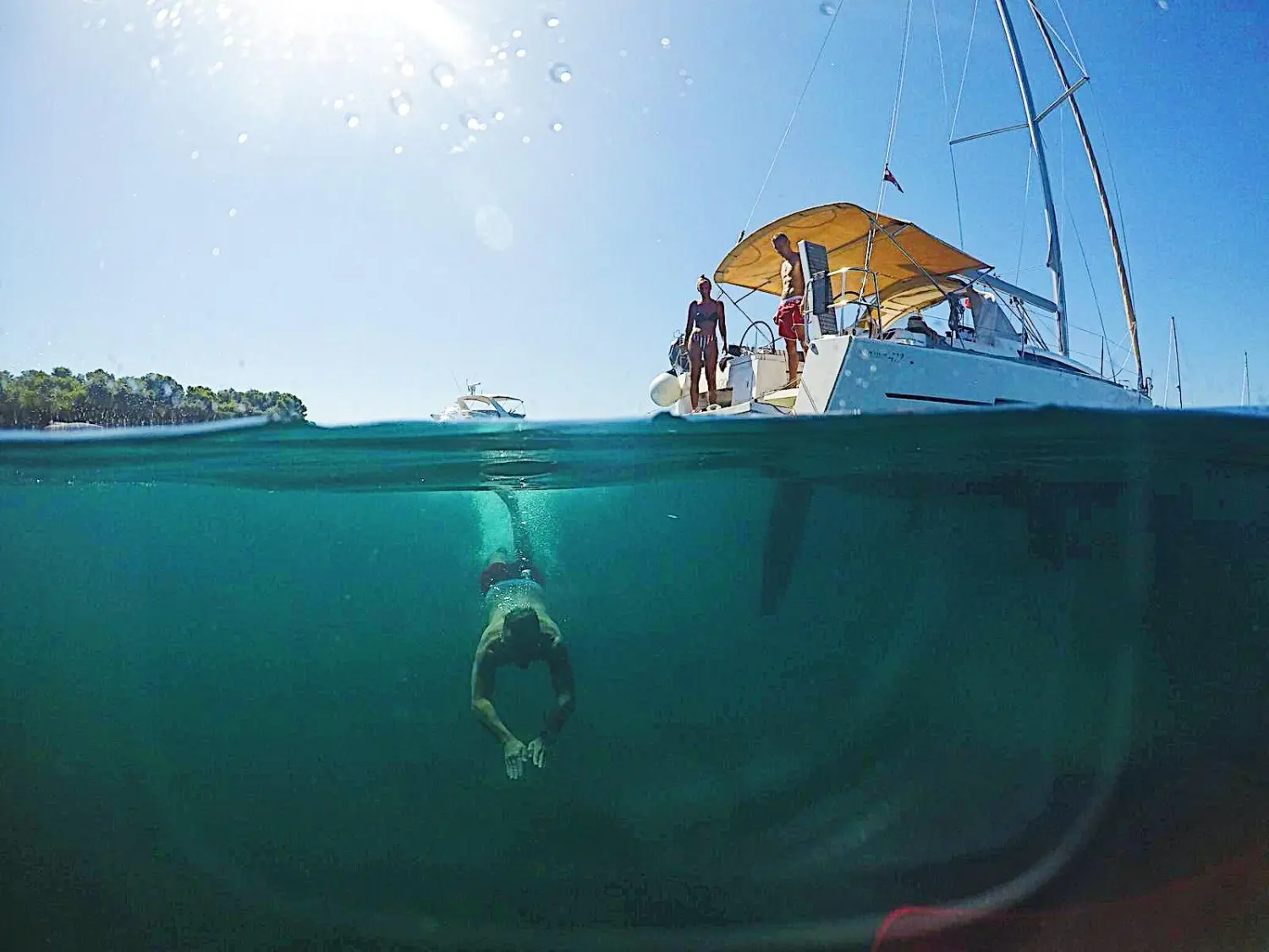 Successful Sailing - ein Boot segelt auf dem Meer und ein Mann taucht unter Wasser